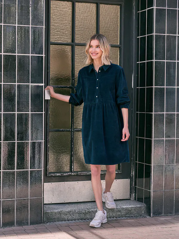 Robe chemise en velours bleu marine, portée avec des baskets blanches