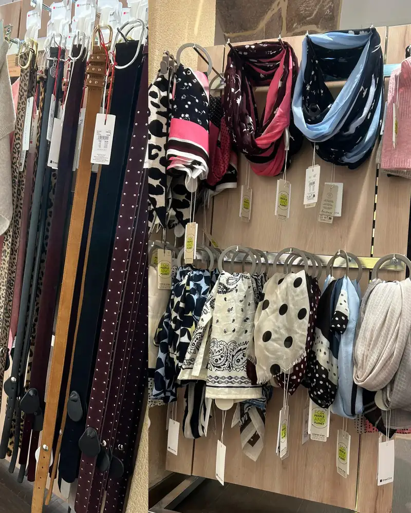 Deux vues des accessoires : des ceintures en cuir, en daim et à motif léopard, et un panneau de foulards et d'écharpes imprimés